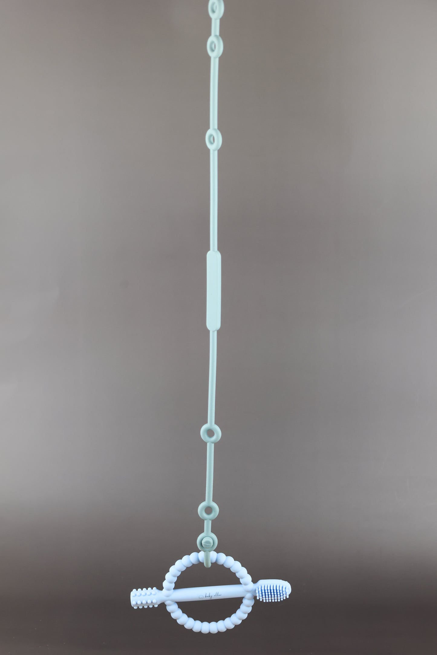 A silicone pacifier strap with a clip and chain design, featuring a pacifier attached to it.