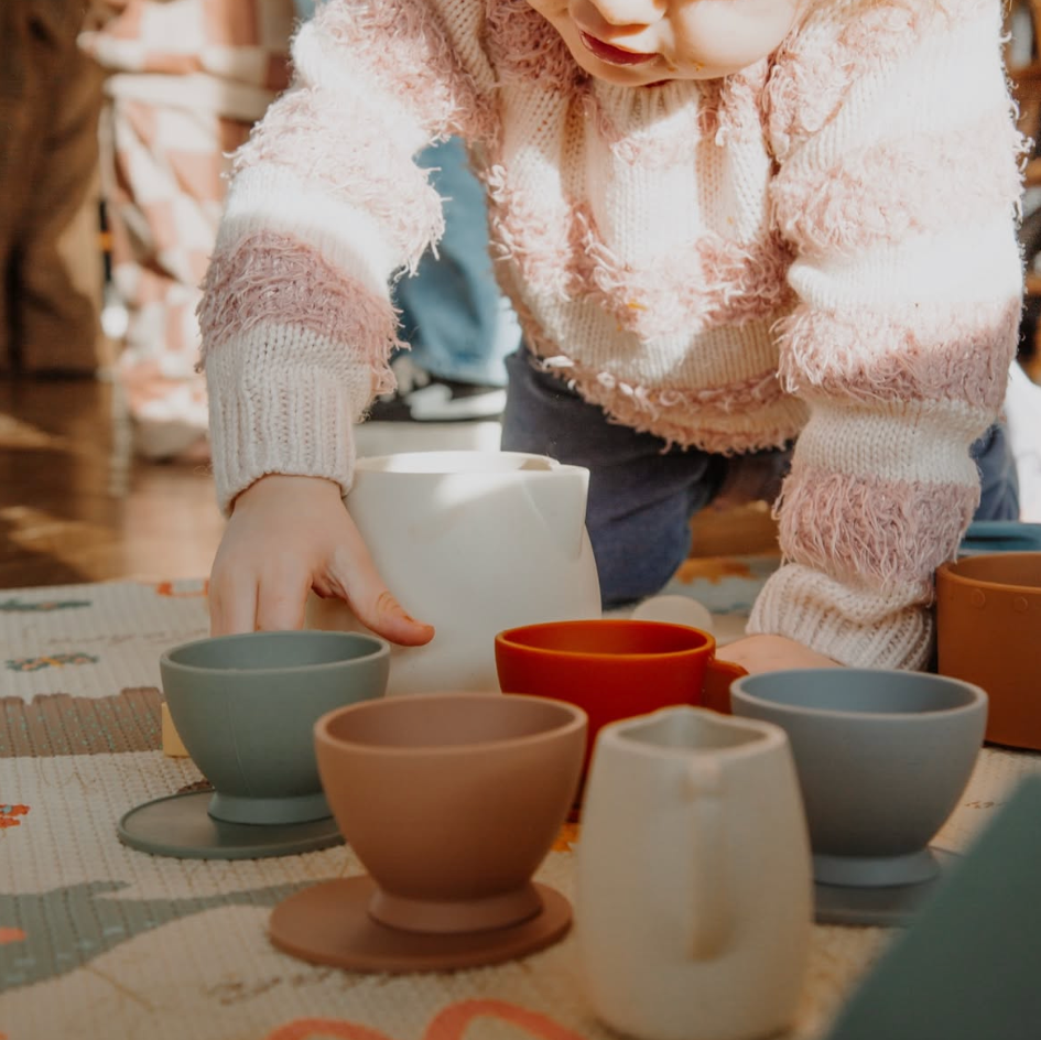 child  interacting with silicone cups on a table