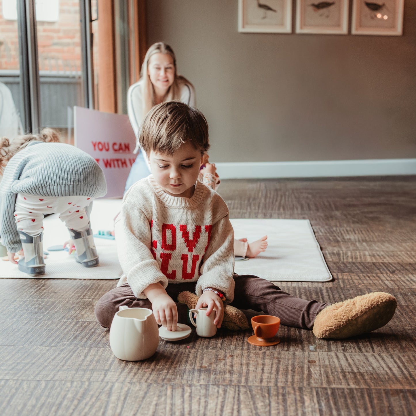 Child playing with toys on a rug in a home setting