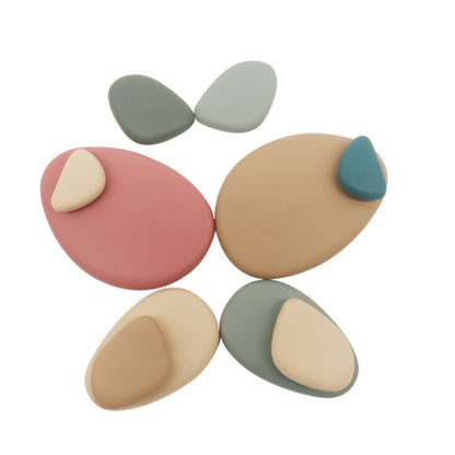 Colorful silicone stacking pebbles by baby ellor, 36-piece set, displayed in various sizes and vibrant shades for toddler play.